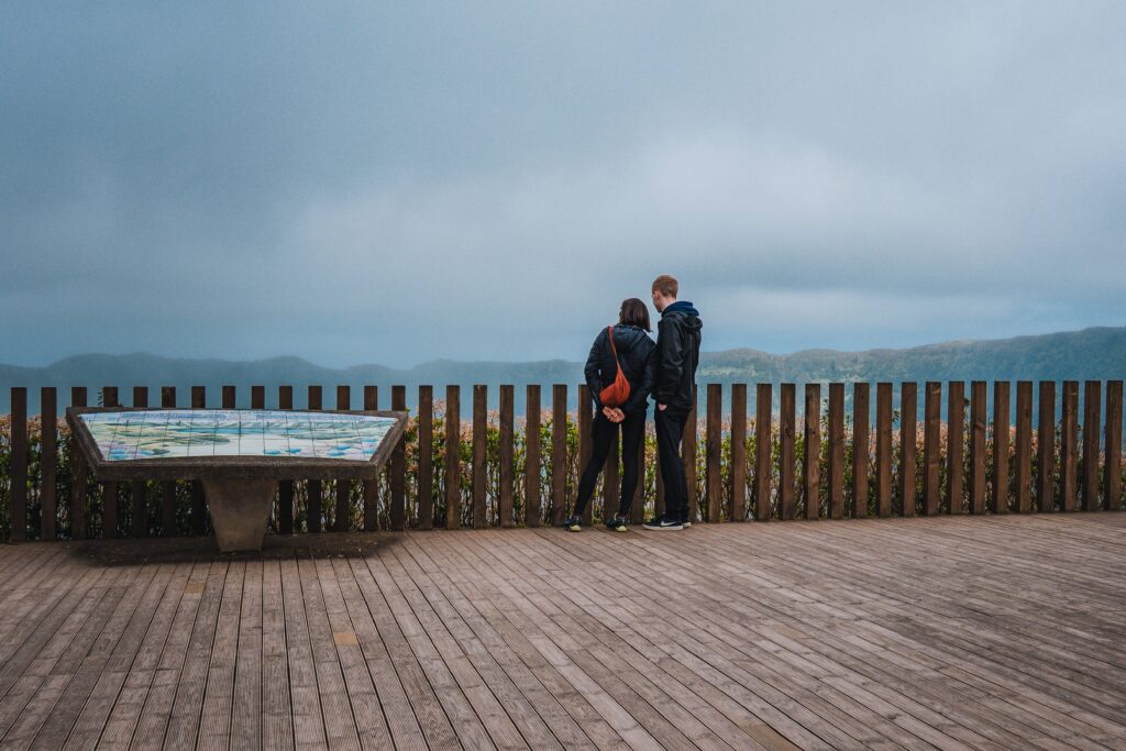 Couple at a viewpoint in São Miguel with a romantic view over a lagoon